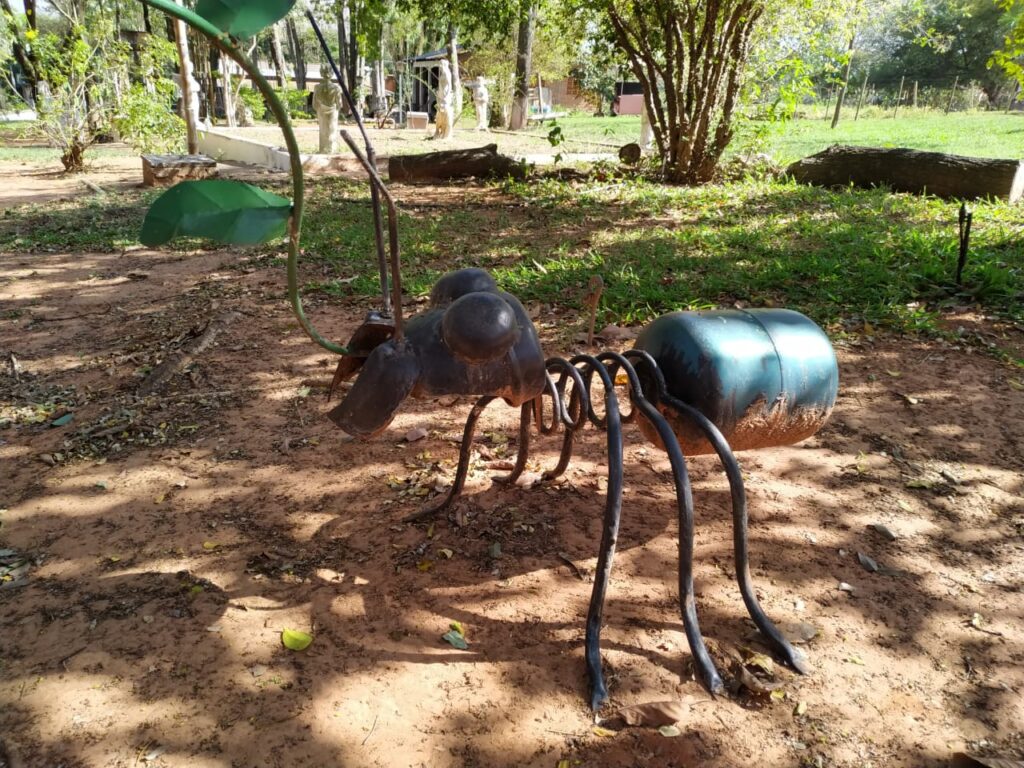Escultura de formiga feita de ferragens exposta em sítio