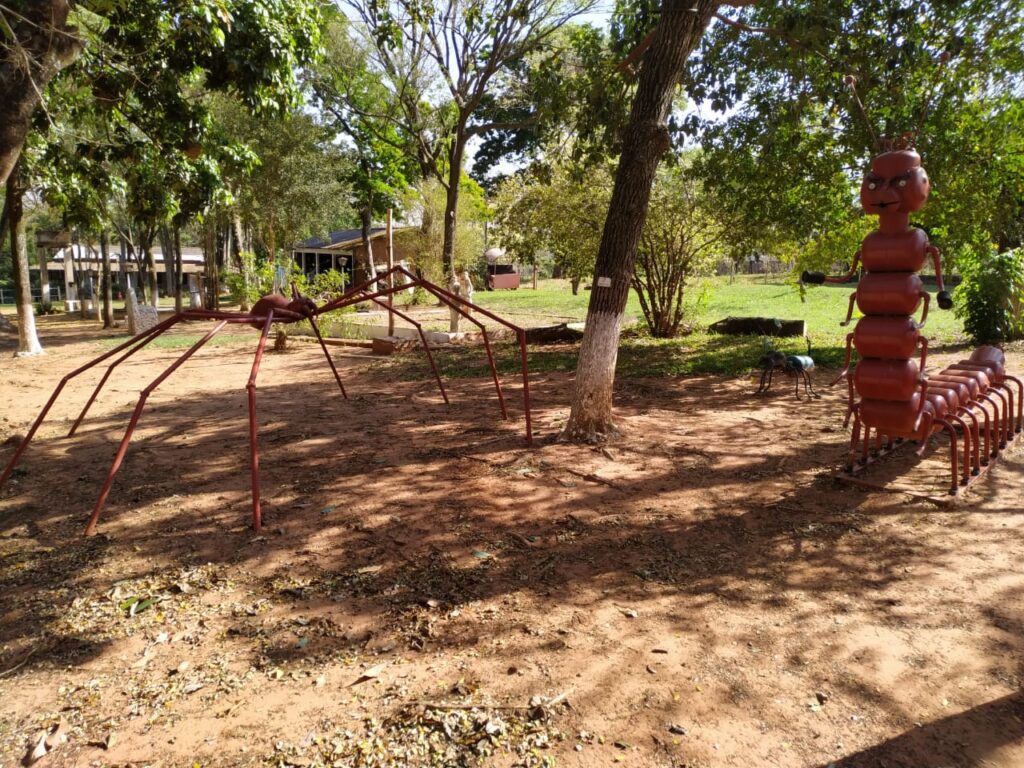 Esculturas de aranha e lagarta feitas de ferragens vermelhas em tamanho grande